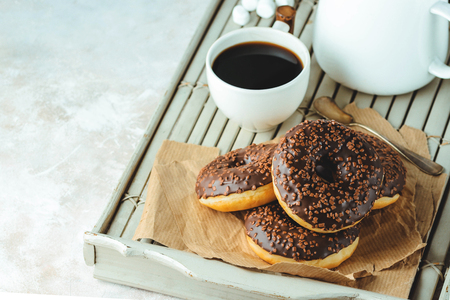 Chocolate donuts and coffee , weekend morning table. Breakfast on a wooden tray. Vintage colorsの写真素材
