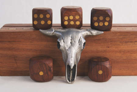 Composition of a trinket of a bulls skull and dice