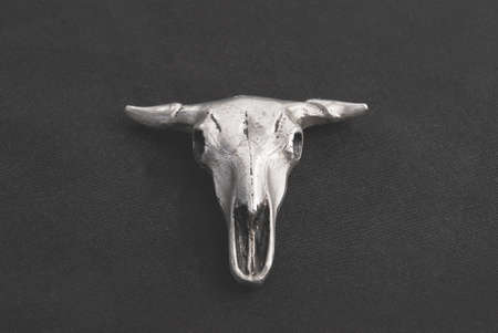 Pendant in the form of a bulls skull on a black backgroundの写真素材