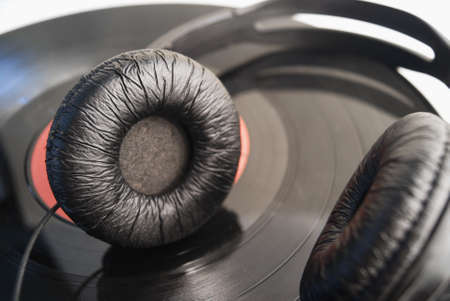 Black headphones on a vinyl record close-up.