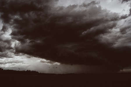 Storm cyclone over summer fields, hills and forests.の写真素材