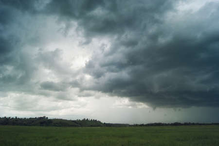Storm cyclone over summer fields, hills and forests.の写真素材