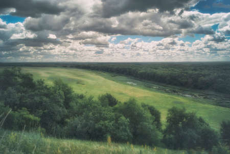Scenic Russian Landscape. Meadows, river and hills under a cloudy skyの写真素材
