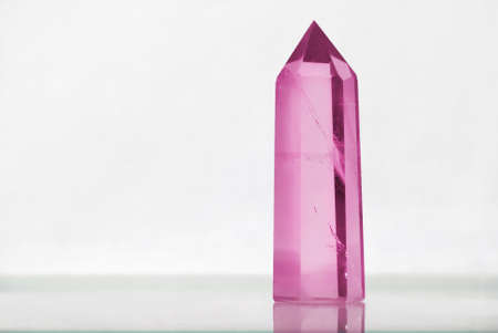 Large clear great royal crystal of quartz chalcedony on white background close up with a lilac pink shade of colorの写真素材