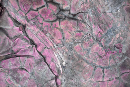 Texture of cracked stones streaked and old crumbling concrete close-up gray color structure.