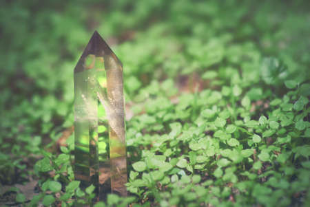 Large mystical faceted quartz crystal on a grass nature background close-up.の写真素材