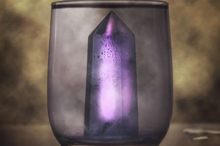 Large quartz crystal on a stump on a background of nature close-up.