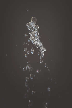 Abstract background, drops of water splash in the air on a light background.の写真素材