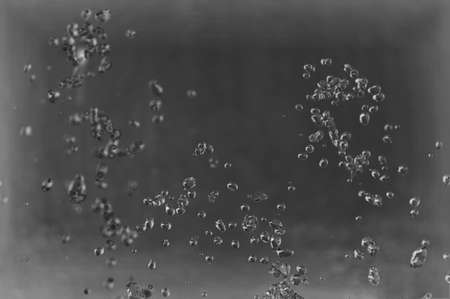 Abstract background, drops of water splash in the air on a light background.の写真素材