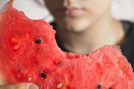 Red juicy watermelon in the hands of a young girl close-up