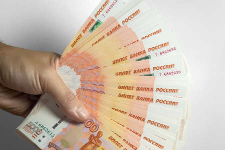 Male hand holds a thick stack of cash money. Million Russian rubles. The concept of rich, wealth, profits, business and finance. Five thousandth bills banknotes. A lots wads of moneyの写真素材