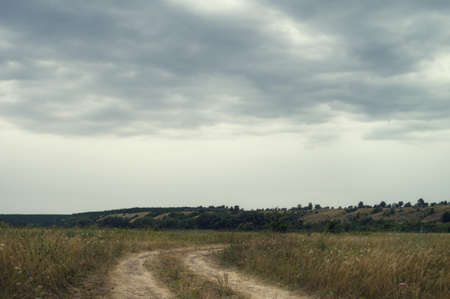 A cloudy day in picturesque summer valley and scenic winding roadの写真素材