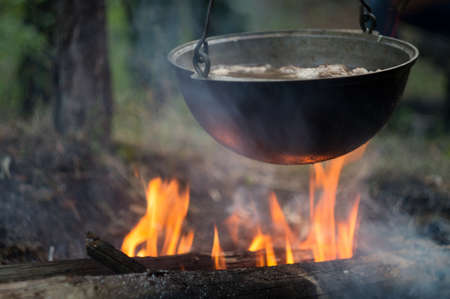 Pot with meat stew, on a fire bonfire in a tourist camp in a wild forest.の写真素材