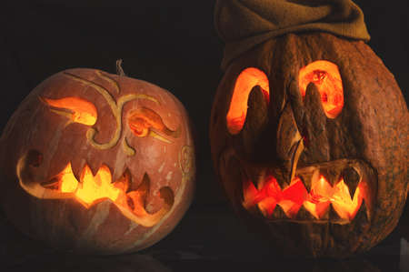 Carved from a pumpkin funny and grim mask. Still life with fresh ripe pumpkin for Halloween. Autumn harvest vegetables.の写真素材
