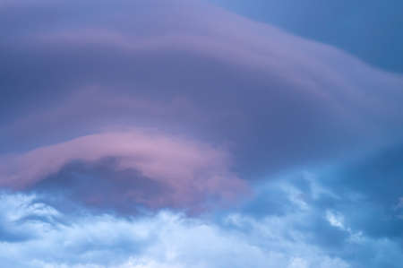 Unusual large beautiful cloud of delicate color on the blue sky. Dreamy cloud form like to strange ufoの写真素材