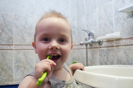 A little boy is brushing his teeth in the bathroomの写真素材