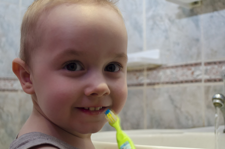 A little boy is brushing his teeth in the bathroomの写真素材
