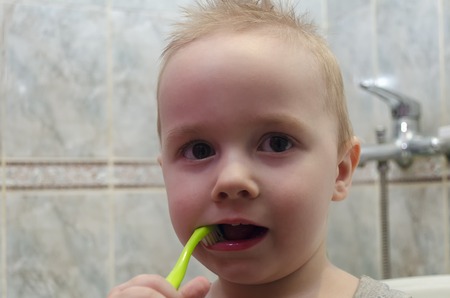 A little boy is brushing his teeth in the bathroomの写真素材