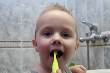 A little boy is brushing his teeth in the bathroomの写真素材