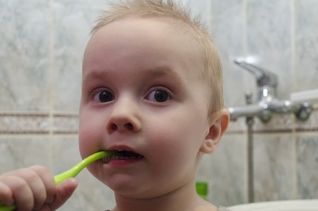 A little boy is brushing his teeth in the bathroomの写真素材