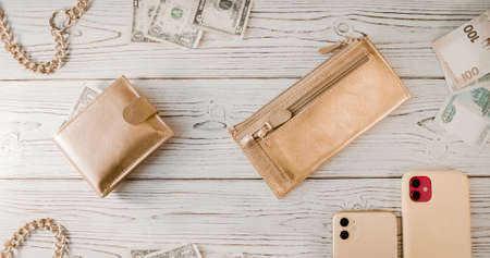 Two gold wallets, a gold chain, dollars, rubles, an two expensive smartphones with two cameras on a...