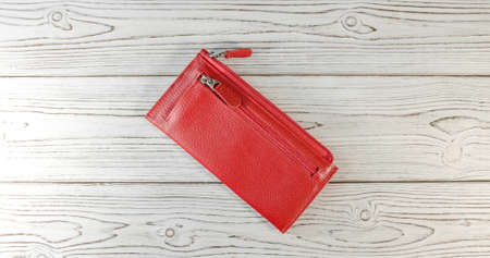 Red wallet on a wooden board background. Top view. Flatlay