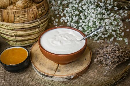 Thick sour cream in a pot on the tableの写真素材