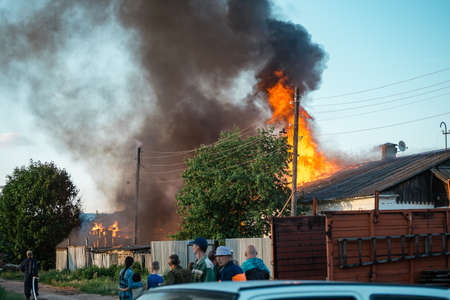 People look at a burning house, a lot of smoke, scary and dangerousのeditorial素材