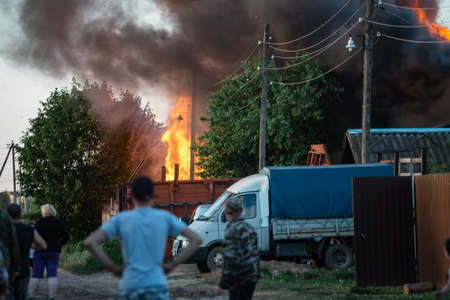 People look at a burning house, a lot of smoke, scary and dangerousのeditorial素材