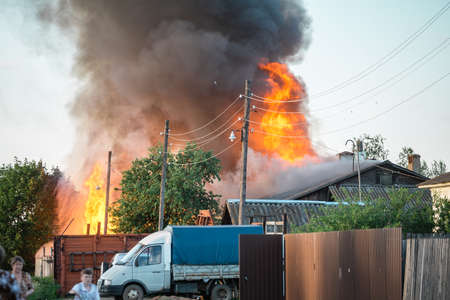The house in the village burns, a lot of smoke, people scatterのeditorial素材