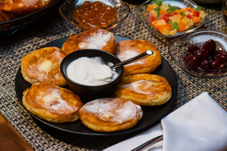 Pancakes with sour cream for breakfast surrounded by oriental sweetsの写真素材