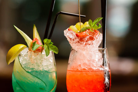 Bright juicy cocktails decorated with fruits and ice in beautiful glassesの写真素材