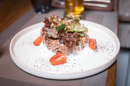 Meat and greens salad with tomatoes on a beautiful plateの写真素材