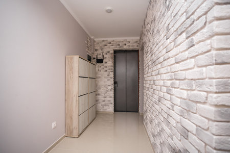 Bright entrance hall with iron door and white brick wallsの写真素材