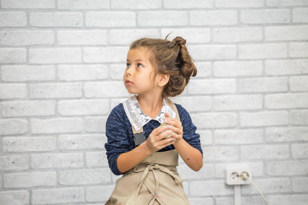 A girl in a blue dress sculpts a clay craft in a pottery workshop