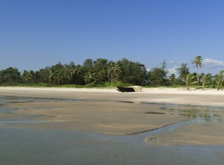 Traditional indian fishing boat in wild beach. South Goa. Indiaの写真素材
