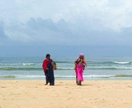 GOA, INDIA - SEPTEMBER 18, 2011: Indian women in traditional dress propose theirs merchandise on Goa beach, SEPTEMBER 18, 2011のeditorial素材