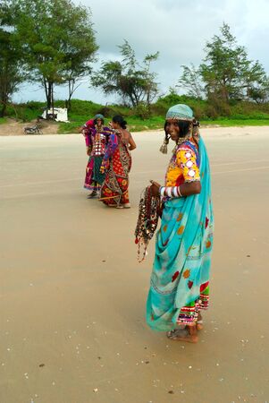 GOA, INDIA - SEPTEMBER 18, 2011: Indian woman in bright sari  poses in front of camera on the Goa beach, SEPTEMBER 18, 2011のeditorial素材