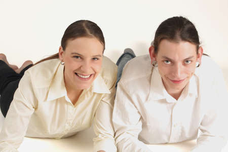 Two young colleagues lying and smiling ahead