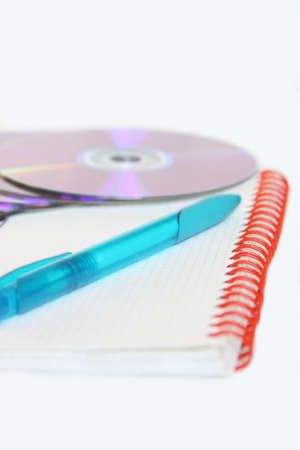 Notebook with pen and CDs isolated on whiteの写真素材