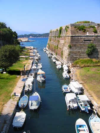 Kerkyra harbour. Fishing boats in canal outside old fortressの写真素材