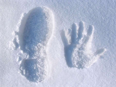 Handprint and footprint in the snowの写真素材