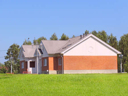 Suburban house of red brick surrounded by lawnの写真素材