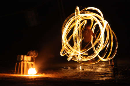 Man Performing with Fire on Beach at Night