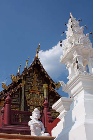 Buddhist temple and carved white tower with wind-bells in Thailand