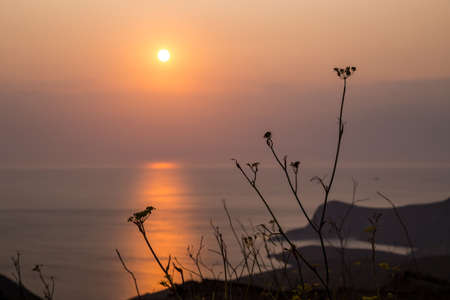 Beautiful sunset over the sea at Syros island, Cyclades. Focus on the foregroundの写真素材