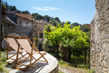 Two deck chairs in a patio. Sunny day in Italy.の写真素材