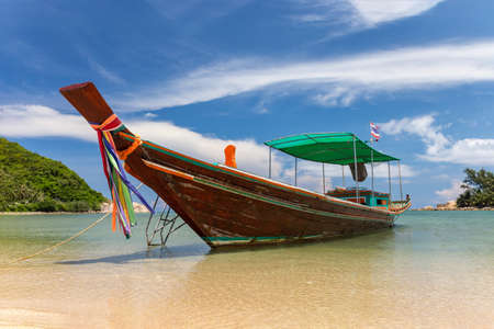 Traditional thai long boat moored at a beachの写真素材
