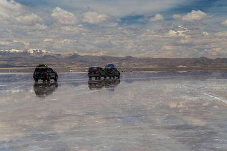 Cars crossing the largest salt flat in the world. Uyuni, Boliviaの写真素材
