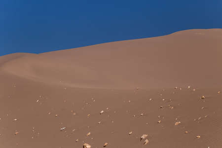 Big sand dune with stones on its slopeの写真素材